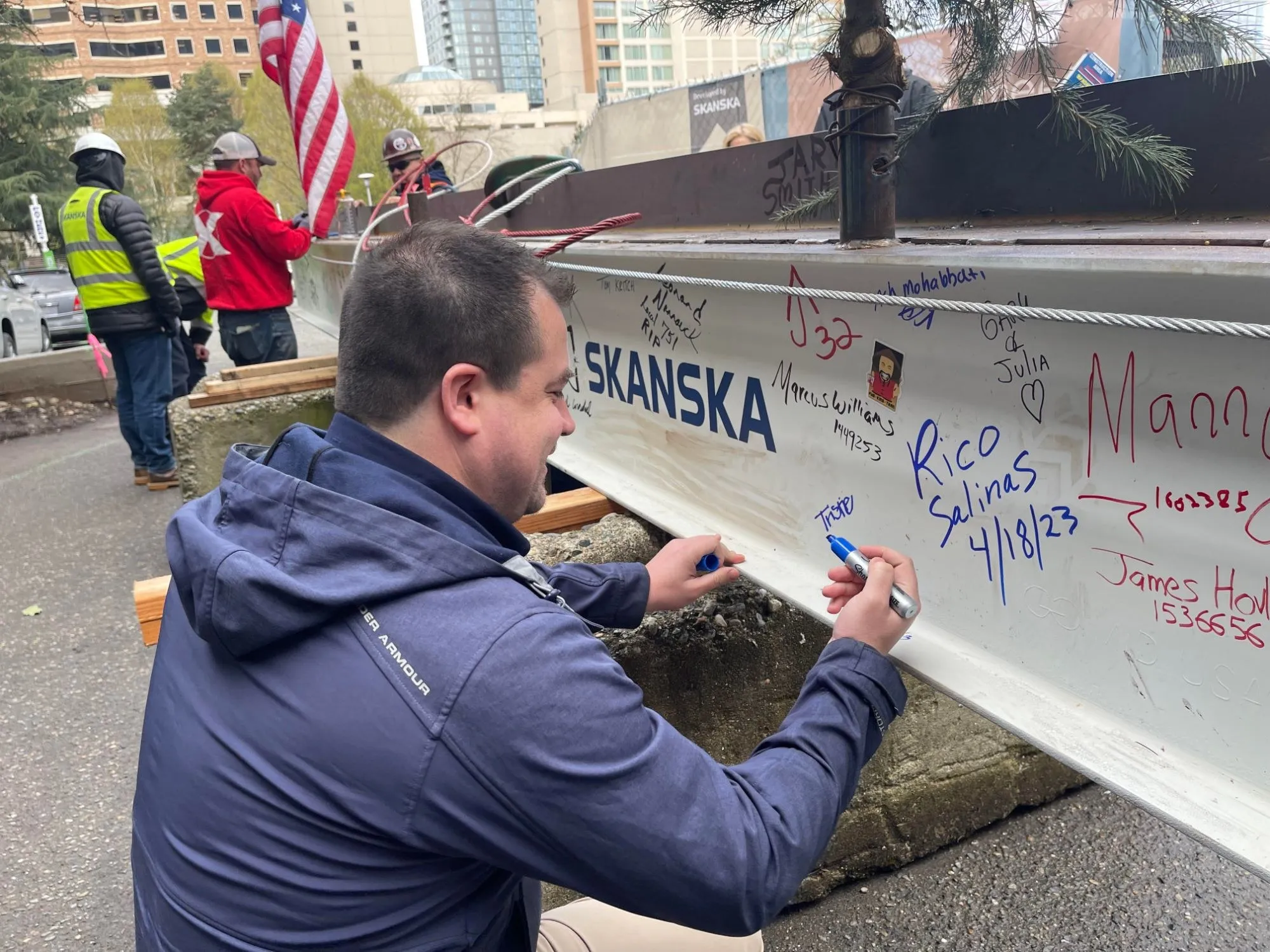 Chris signing the final steel beam at a Skanska topping-out ceremony